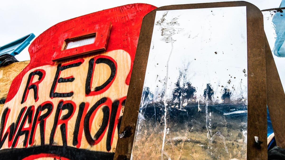 One of Cannupa Hanska Luger’s mirror shields reflects police in riot gear at Standing Rock.