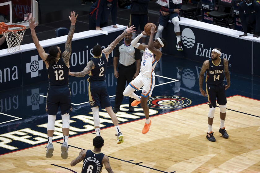 Oklahoma City Thunder guard Shai Gilgeous-Alexander (2) shoots over New Orleans Pelicans guard Lonzo Ball (2) and center Steven Adams (12) in the fourth quarter of an NBA basketball game in New Orleans, Wednesday, Jan. 6, 2021. (AP Photo/Derick Hingle)