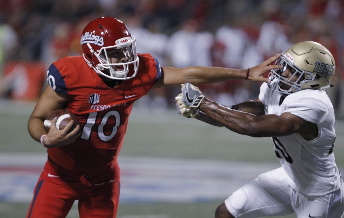 Fresno State quarterback Jorge Reyna stiff-arms Idaho's Dorian Clark during a game in September 2018.