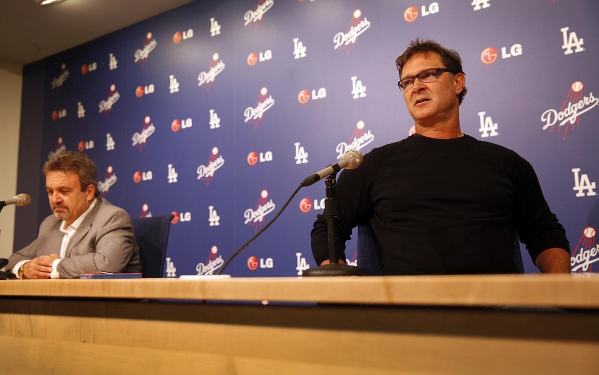 Dodgers Manager Don Mattingly, right, speaks at a news conference while sitting near Dodgers General Manager Ned Colletti on Monday. Mattingly is not happy with his current contract situation with the team.