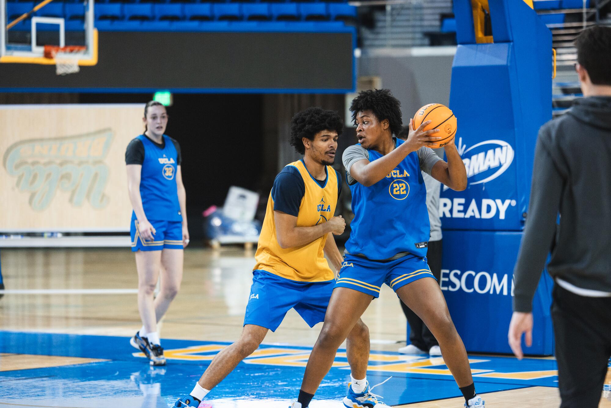 Scout team player Jonny Garnett guards forward Christeen Iwuala during a UCLA women's basketball practice.