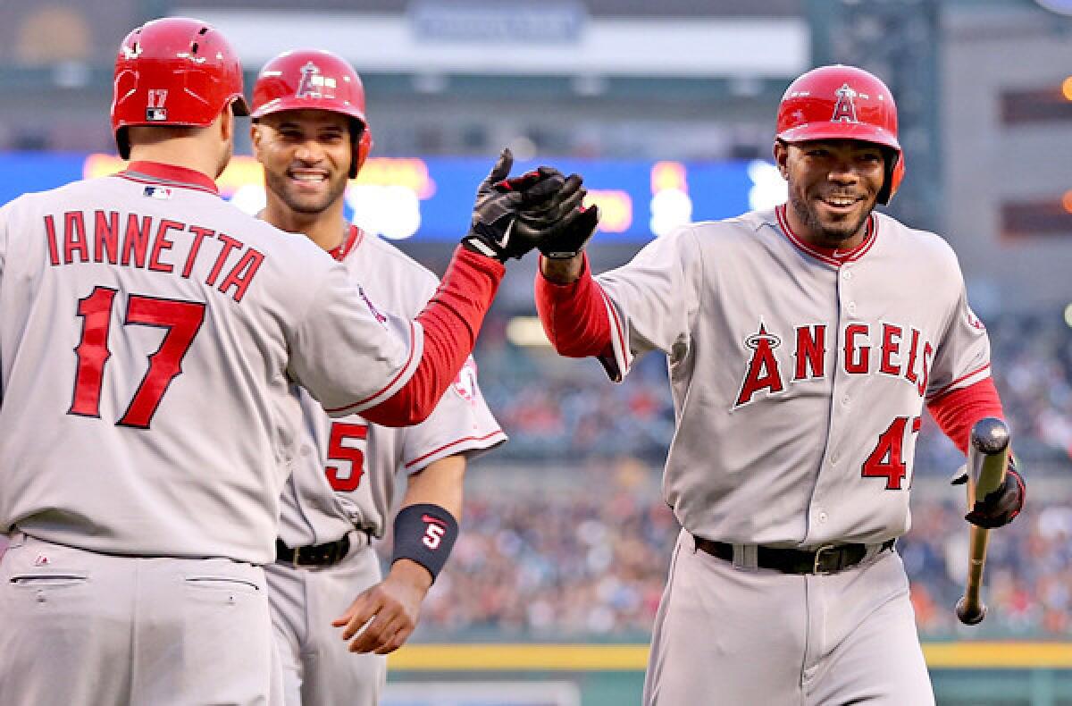 Angels second baseman Howie Kendrick is congratulated by teammate Chris Iannetta after hitting a two-run home run against the Tigers that drove in Albert Pujols (5) in the third inning Friday night in Detroit.