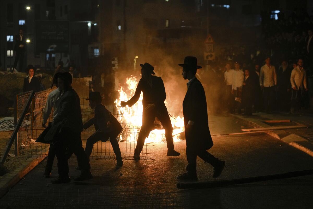 Ultra-Orthodox Jewish men burn trash during a protest against army recruitment in Jerusalem.
