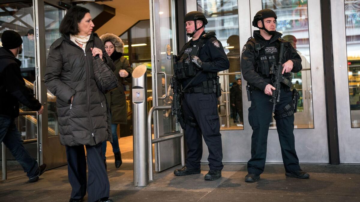 Members of the New York City Police Department stand guard during the morning rush hour at an entrance to New York Port Authority Bus Terminal on Tuesday.