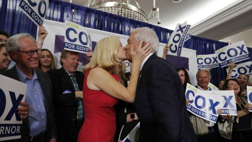 Surrounded by supporters, California Republican gubernatorial candidate John Cox is greeted at the podium with a kiss from his wife, Sarah, before speaking at his California Primary election night party at the U.S. Grant Hotel in San Diego.