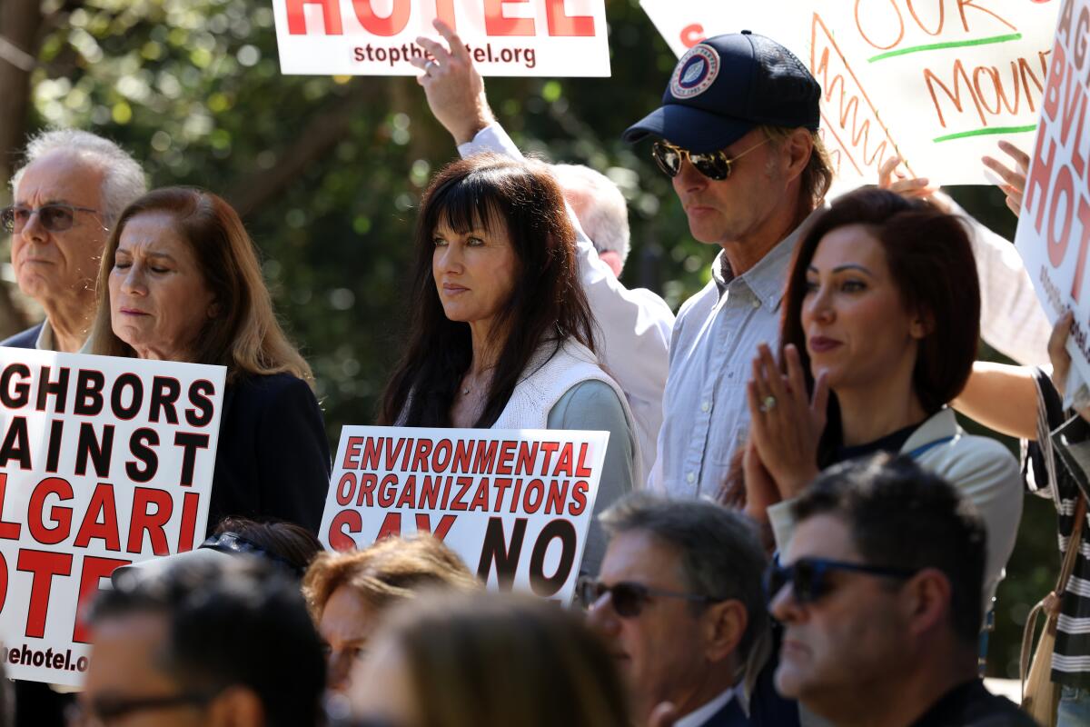 People at a rally, including some holding signs against the proposed Bulgari hotel