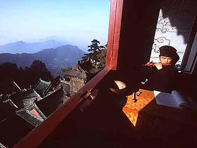 His music floating into the valley below, Taoist apprentice Zheng Sui Cheng plays a flute in a temple on 5,287-foot Tianzhu, or "pillar to hold up heaven," one of the 72 peaks in the Wudang mountain range.