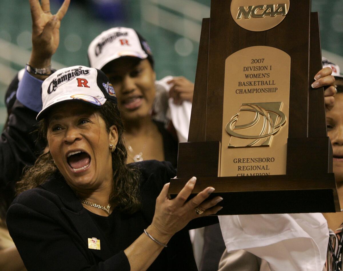 Coach C. Vivian Stringer wears a Champions hat and holds a trophy after Rutgers win.