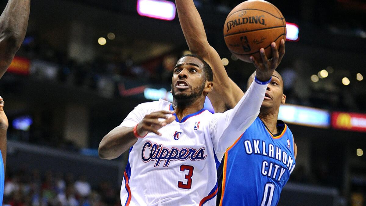 Clippers point guard Chris Paul puts up a shot in front of Oklahoma City Thunder point guard Russell Westbrook during Game 4 of the Western Conference semifinals in May. The Clippers open the 2014-15 season against Oklahoma City on Oct. 30.