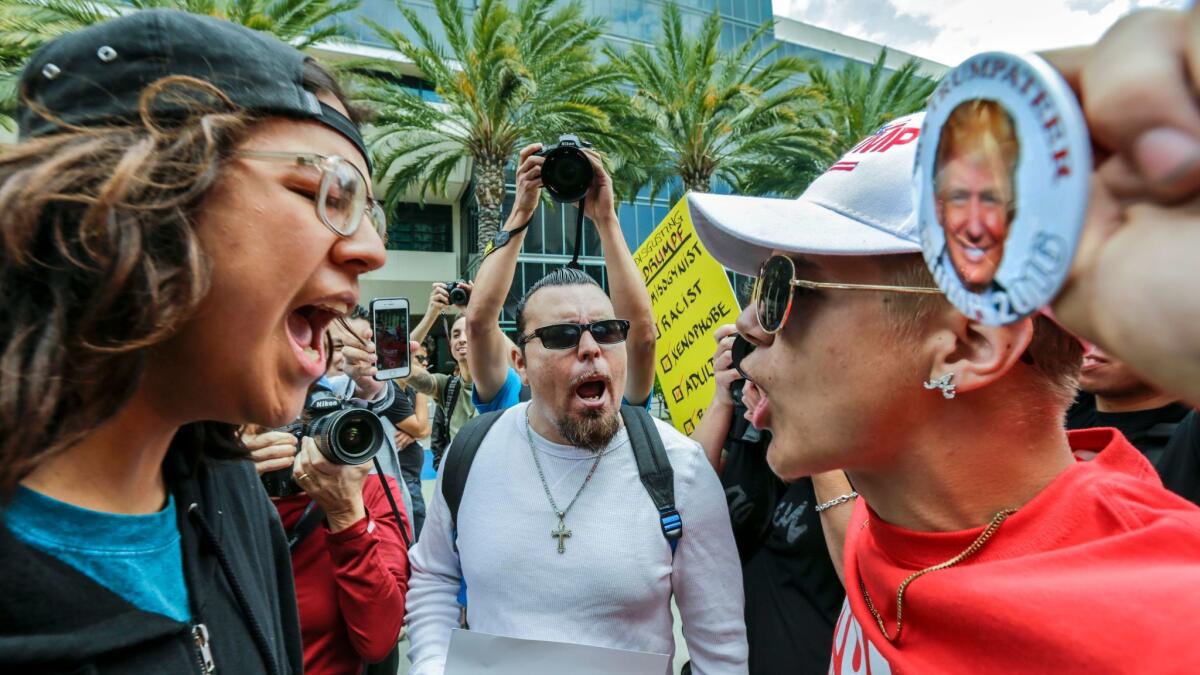 Joshua Gonzalez, left, confronts Trump supporter Jake Towe, right, outside the Anaheim Convention Center during a Trump rally.