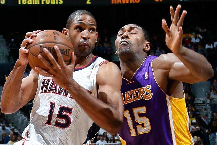 Metta World Peace, shown defending Atlanta's Al Horford, has kept his Twitter followers entertained, if not informed on his status with the Lakers.