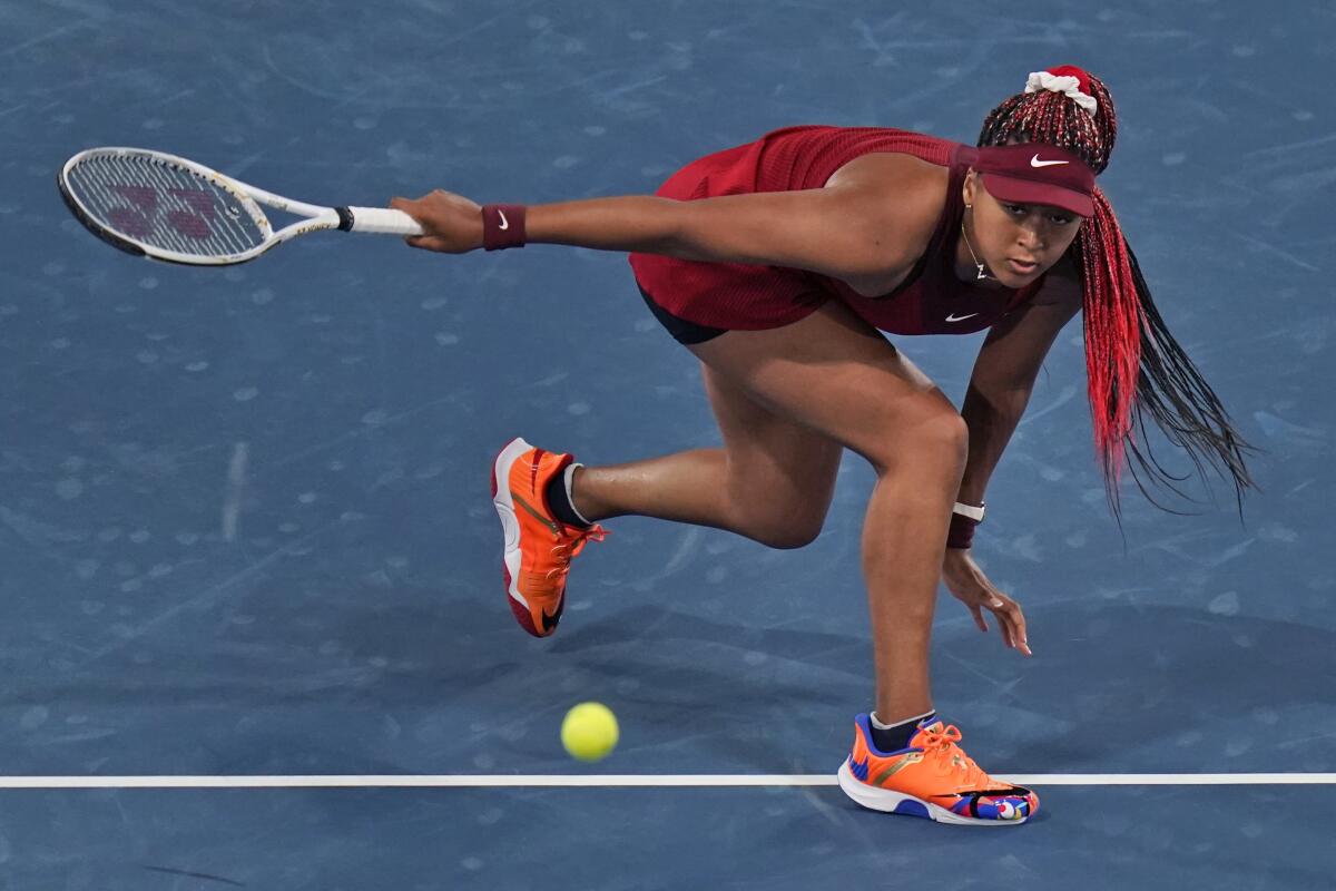 Naomi Osaka lunges for the ball.