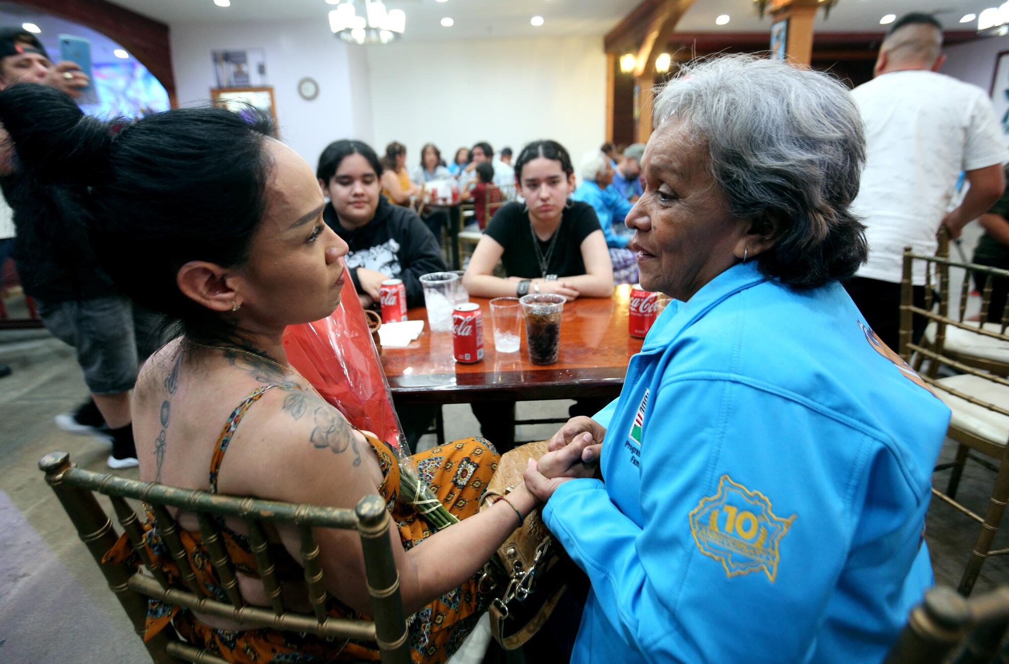 Nadia Ortega, 40 of West Covina, left, holds hands and talks with her mother Beatriz Ortega, 63.