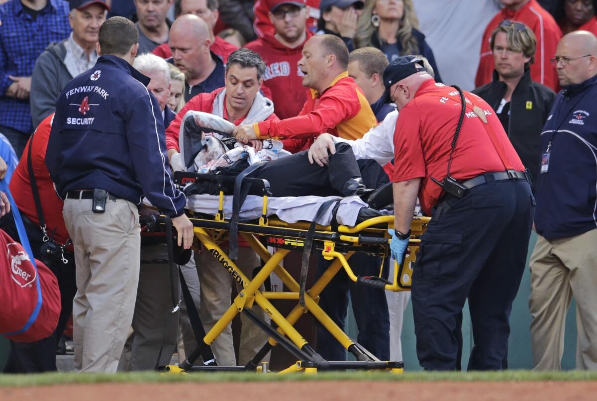 Un fan es llevado tras el batazo que sufrió en Fenway Park.