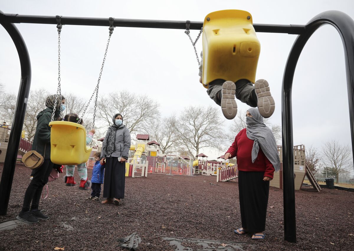 Afghan refugee mothers and children play in a park in Liberty Village on Joint Base McGuire-Dix- Lakehurst in Trenton, N.J., Thursday, Dec. 2, 2021. (Barbara Davidson/Pool via AP)