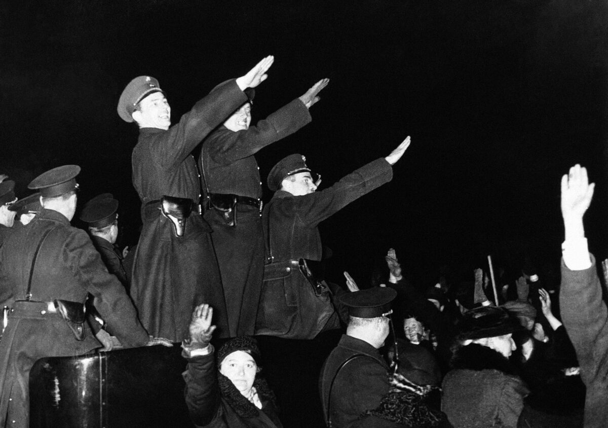 A crowd with many giving the Nazi salute in a black and white photo