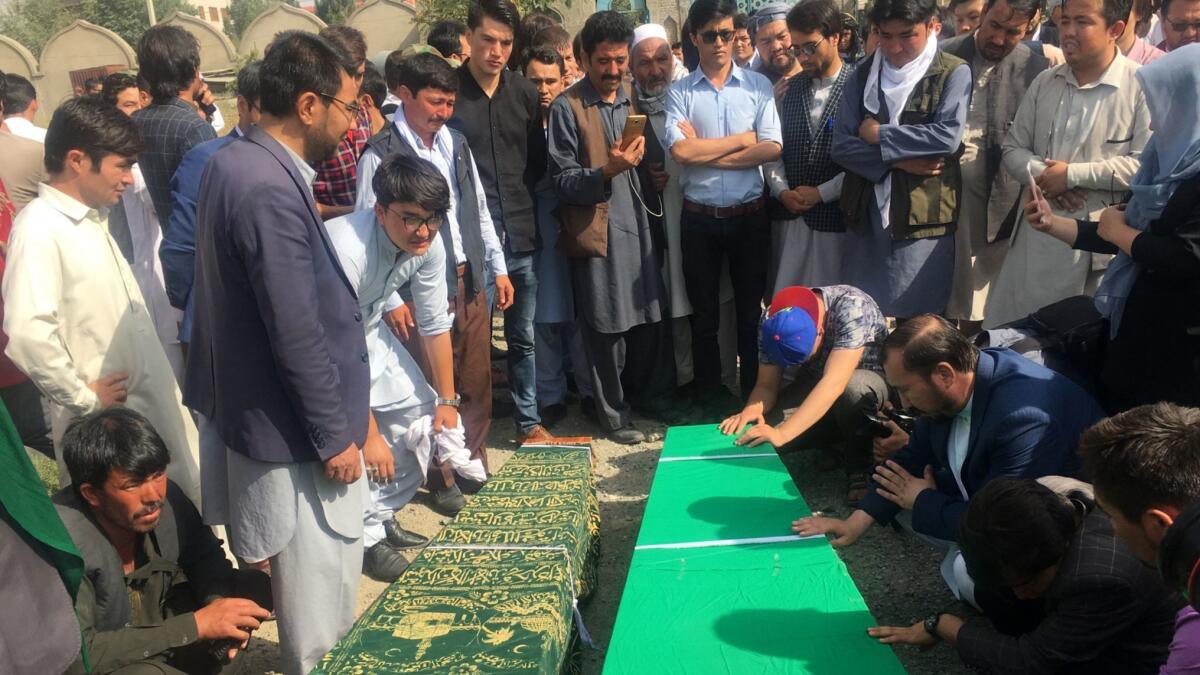 Relatives pray near victims of Wednesday's suicide bombing in western Kabul.