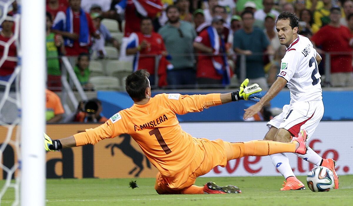 Forward Marco Urena sends a shot past Uruguay goalkeeper Fernando Muslera to provide the final margin of victory for Costa Rica in a World Cup Group D game.