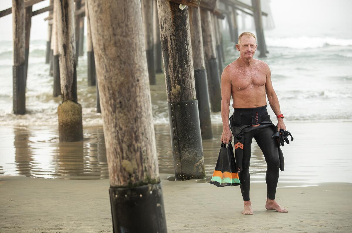 Kenneth Mullinix prepares for a swim in the ocean near the Newport Beach Pier on Friday.