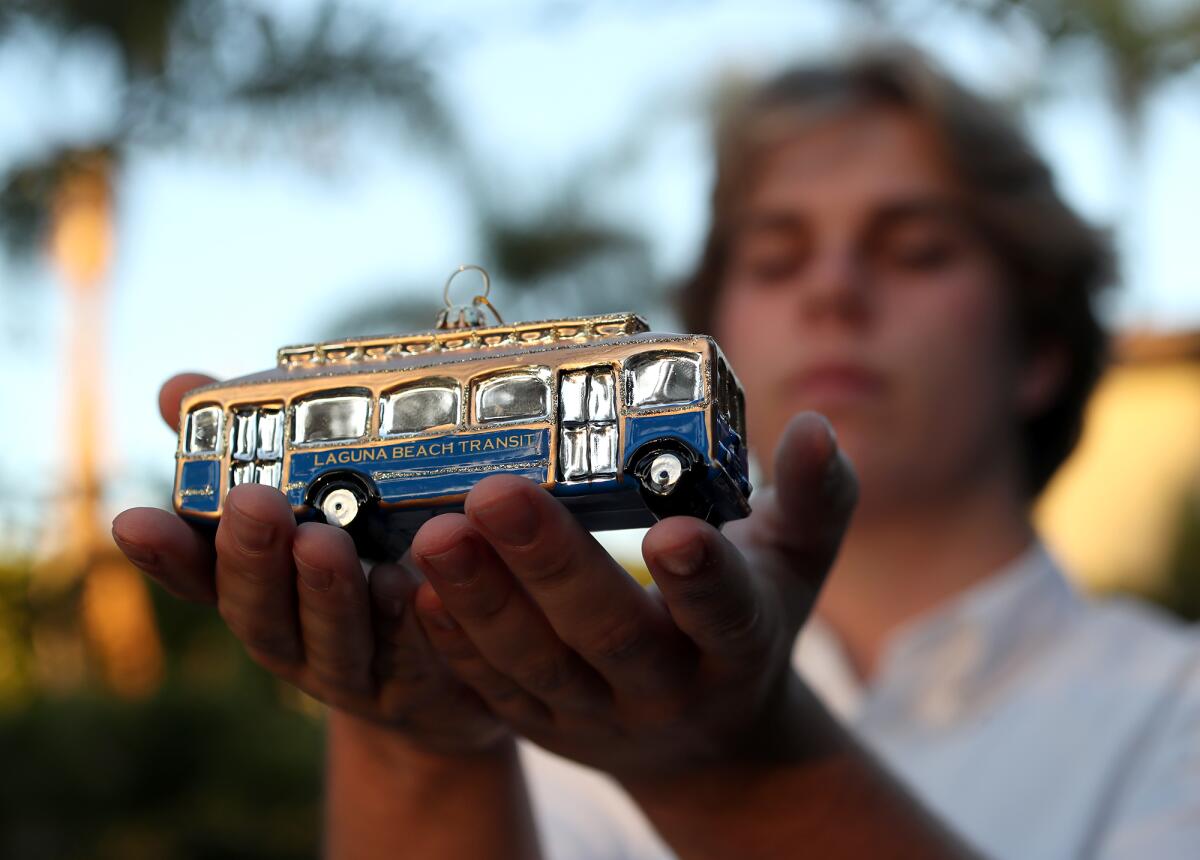 Jackson Collins holds one of his ornaments, the trolley bus, in Laguna Beach.