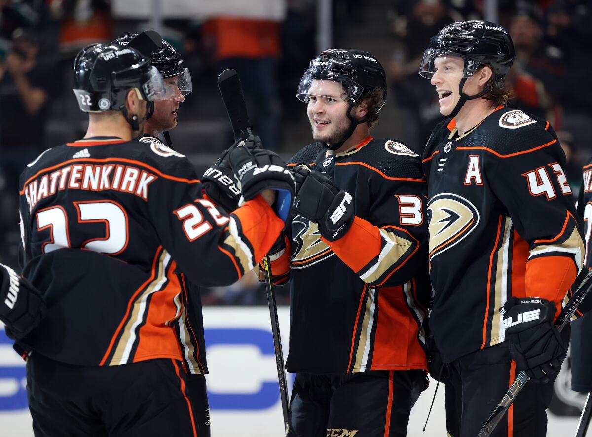 Ducks rookie Mason McTavish, center, celebrates with teammates Kevin Shattenkirk and Josh Manson.