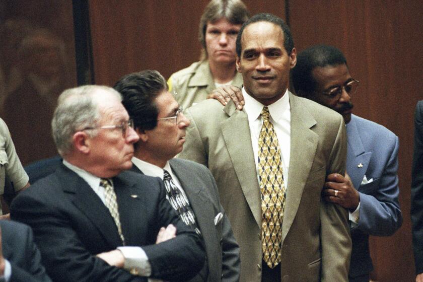 ARCHIVO - En esta fotografía de archivo del 3 de octubre de 1995, el abogado Johnnie Cochran Jr. sostiene a O.J. Simpson mientras se lee el veredicto de no culpabilidad en una sala del tribunal de Los Ángeles durante su juicio en Los Ángeles. Los abogados defensores F. Lee Bailey, izquierda, y Robert Kardashian miran. O.J. Simpson, el laureado astro del fútbol americano y actor de Hollywood que fue absuelto de los cargos de doble asesinato de su exesposa y su amigo, pero luego declarado responsable en un juicio civil aparte, ha fallecido. Tenía 76 años. (Myung J. Chun/Los Angeles Daily News via AP, Pool, archivo)