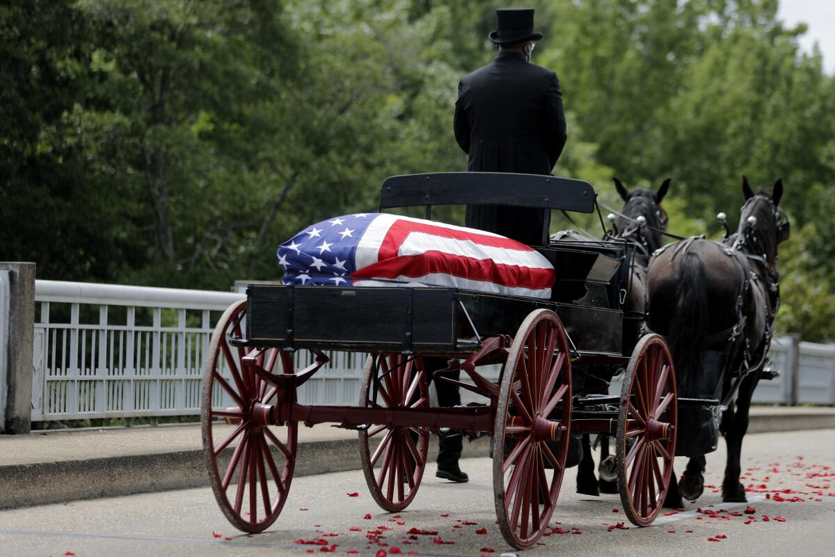 The casket of Rep. John Lewis moves over the Edmund Pettus Bridge by horse drawn carriage during a memorial service for him.