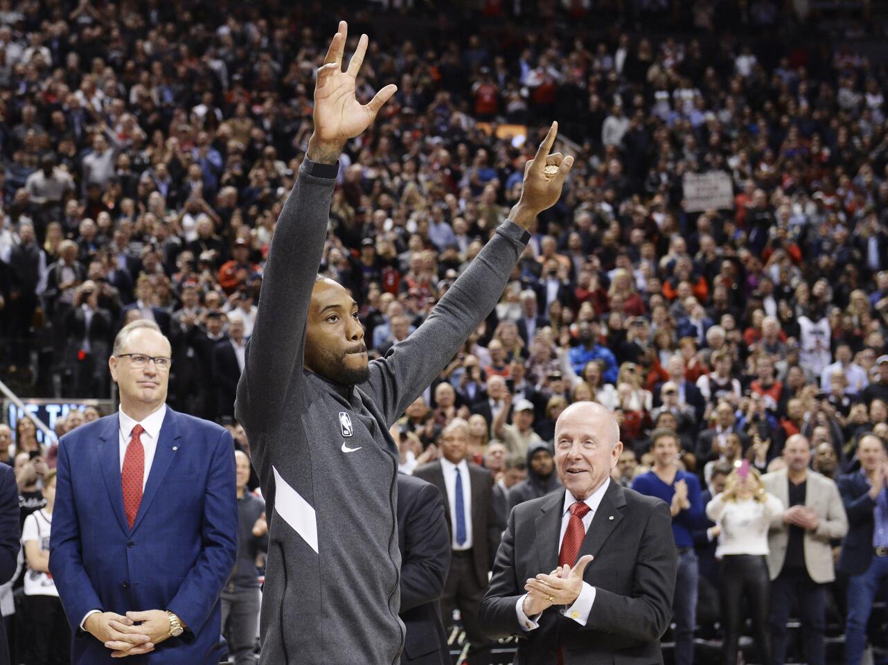 Former Toronto Raptors and now Los Angeles Clippers forward Kawhi Leonard salutes the crowd as he receives his 2019 NBA championship ring prior to an NBA basketball game, Wednesday, Dec. 11, 2019, in Toronto. (Nathan Denette/The Canadian Press via AP)