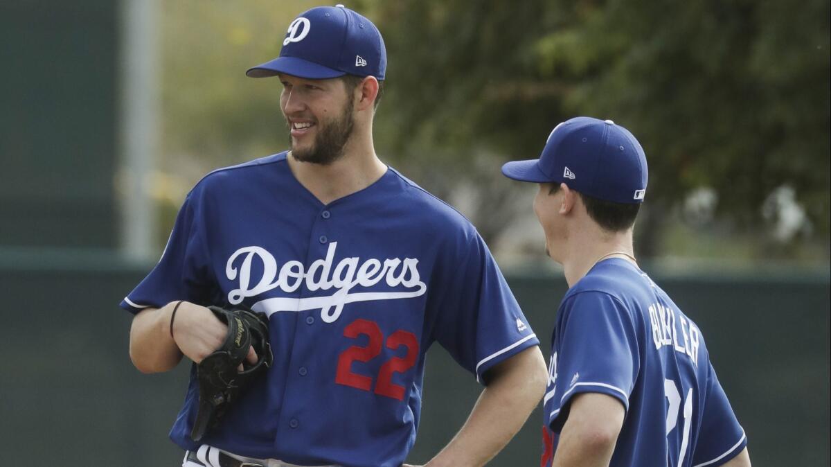 Dodgers starting pitchers Clayton Kershaw, left, and Walker Buehler talk during a spring-training workout in February.
