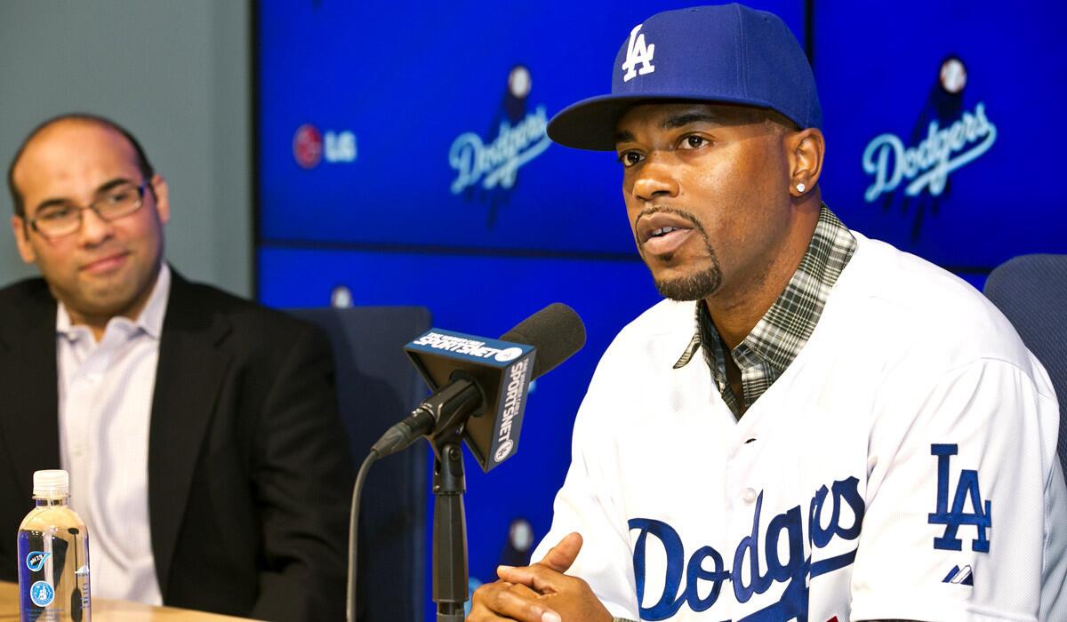 Dodger General Manager Farhan Zaidi, left, introduces newly acquired infielder Jimmy Rollins at Dodger Stadium on Wednesday.