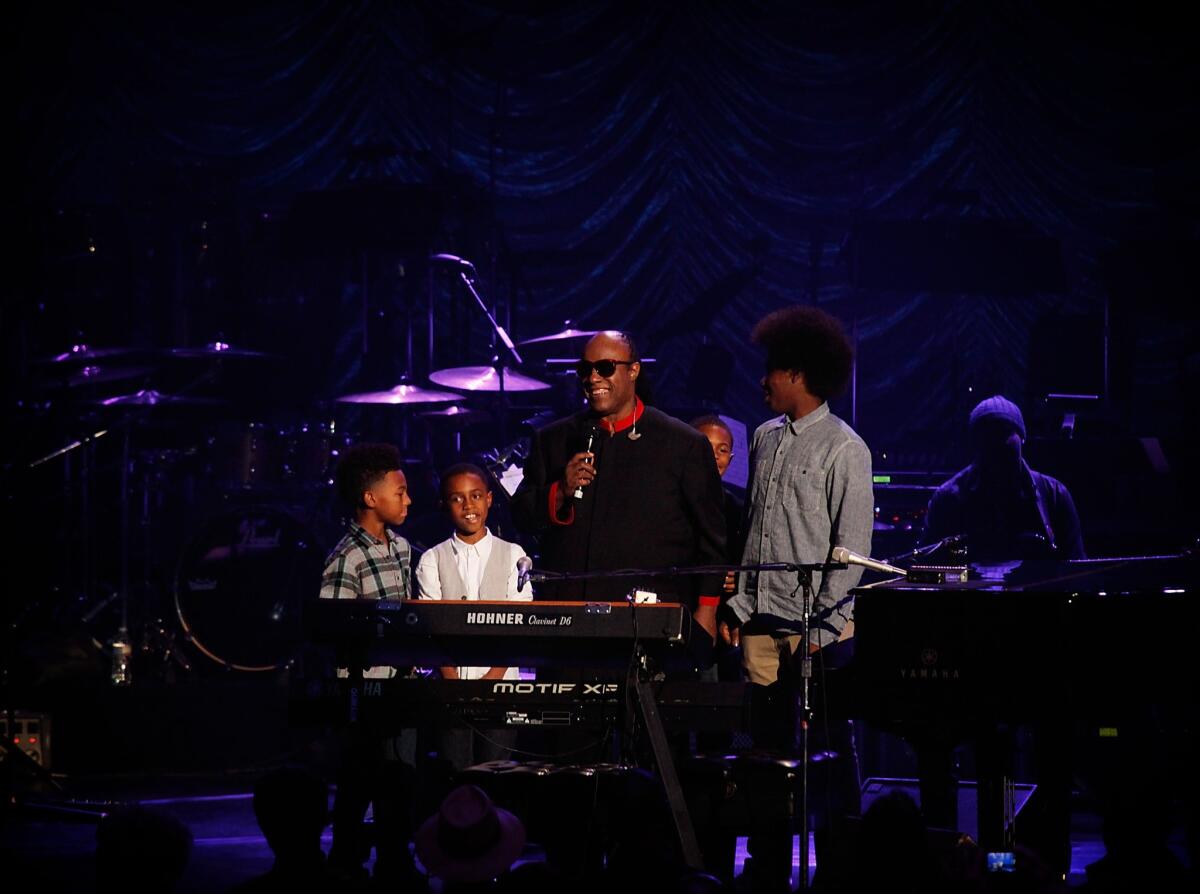 Stevie Wonder performs on stage with his grandchildren during his 18th annual House Full of Toys benefit concert.