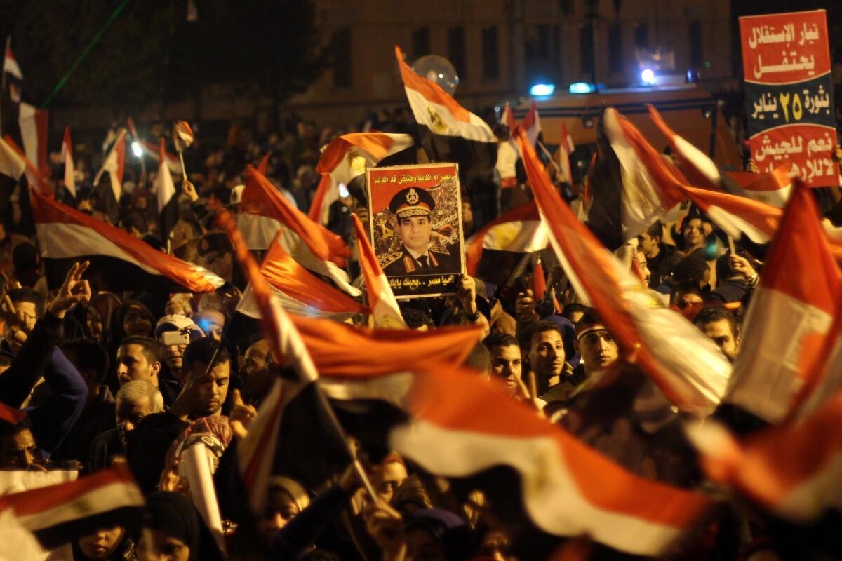 Egyptians wave the national flag and hold up pictures of Gen. Abdel-Fattah Sisi during a gathering at the edges of Cairo's Tahrir Square on Saturday.