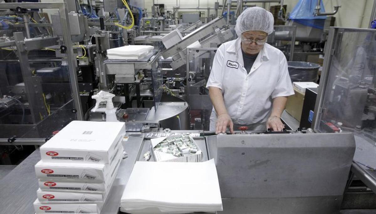 Rhonda Huskelhus monitorea una máquina empacadora de paquetes de mantequilla en Grassland Dairy Products Inc. en Greenwood, Wisconsin.