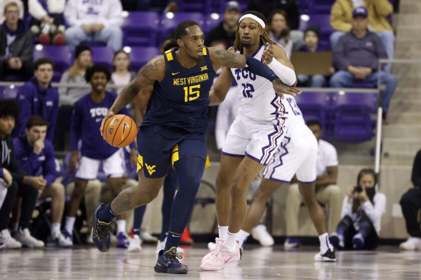 West Virginia forward Jimmy Bell Jr. (15) works to get past TCU forward Xavier Cork (12) in the first half of an NCAA college basketball game, Tuesday, Jan. 31, 2023, in Fort Worth, Texas. (AP Photo/Ron Jenkins)
