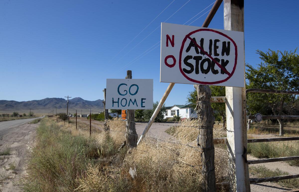 Signs unwelcoming alien enthusiasts on a roadside fence in front of a home in the Area 51 adjacent town of Rachel, NV.