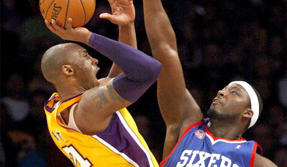 Kobe Bryant shoots over former teammate Kwame Brown on Jan. 1, 2012. Brown was waived by the Philadelphia 76ers on Wednesday.