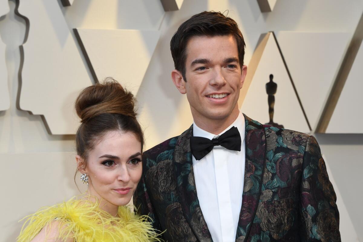 John Mulaney and Anna Marie Tendler taking a photo together at the Oscars.