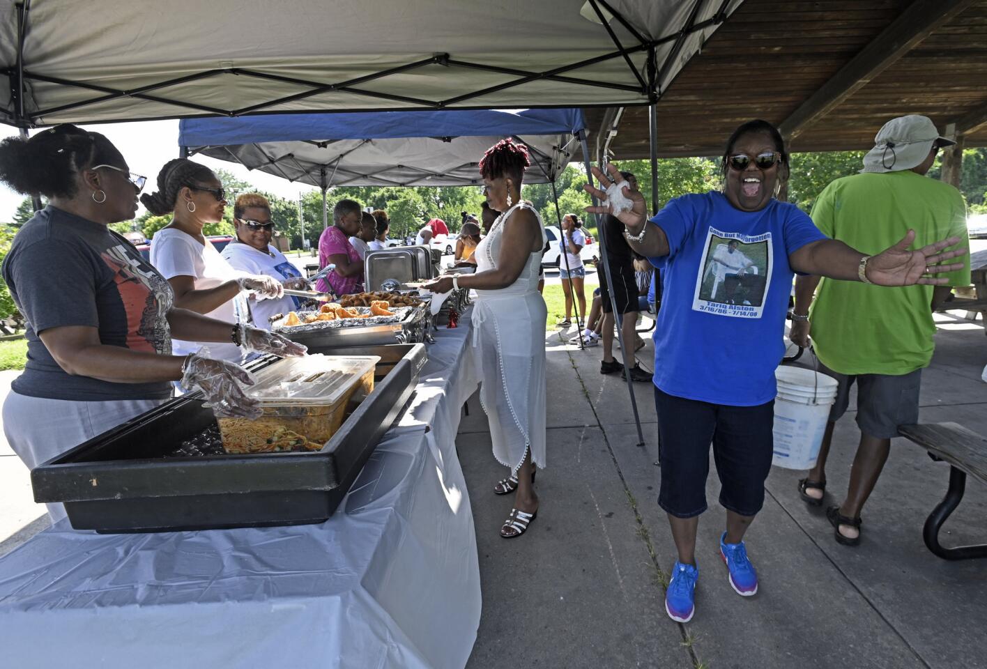Daphne Alston, right, dances near the food line during the 10th annual Tariq's Memorial Cookout at Turner Station Park. Her son Tariq Alston, 22, was killed July 14, 2008 in Joppa and the case remains unsolved.