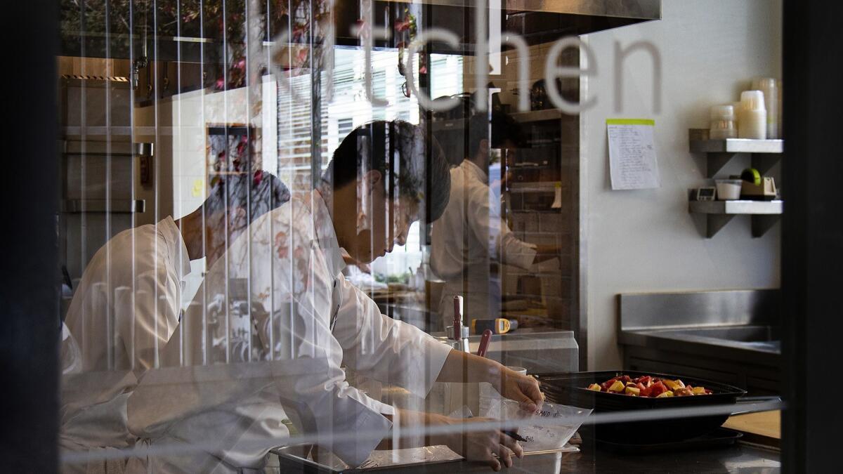 Sous chefs prep for dinner service at Benu, an environmentally friendly restaurant in San Francisco.