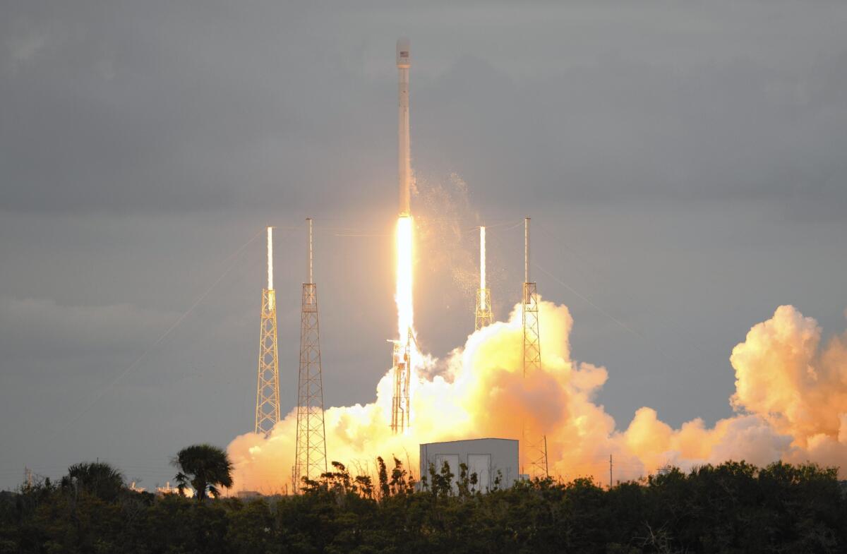 A SpaceX rocket lifts off last year. The company plans to launch a rocket Tuesday carrying space station cargo, then land its engines on an ocean barge.