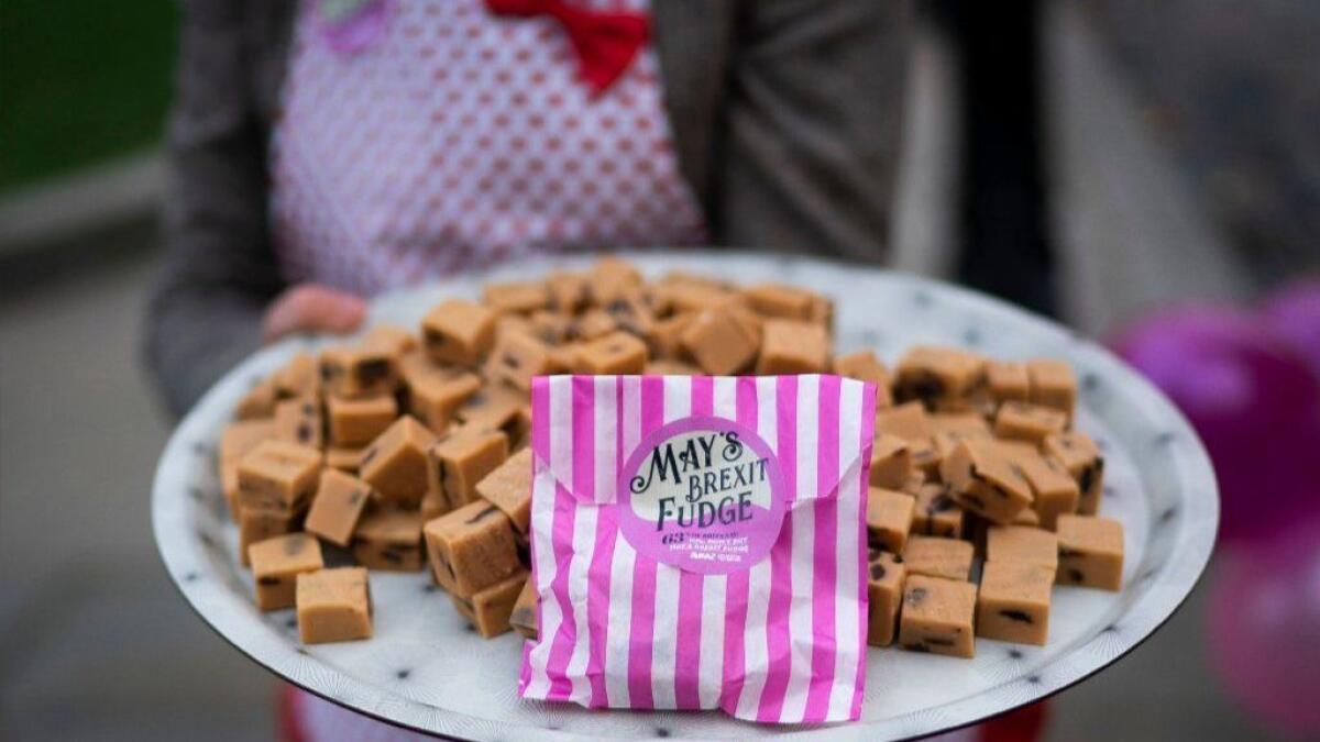 Anti-"Brexit" campaigner dressed as British Prime Minister Theresa May holds a plate of fudge outside Houses of Parliament in London. May put off a vote in the House of Commons on her draft agreement with the European Union.