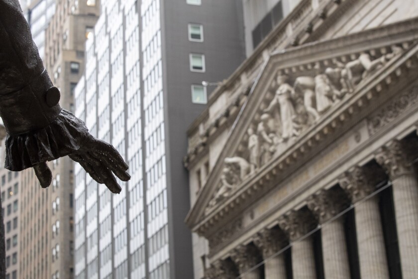 Rain drops hang from the hand of a statue of George Washington across the street from the New York Stock Exchange. 