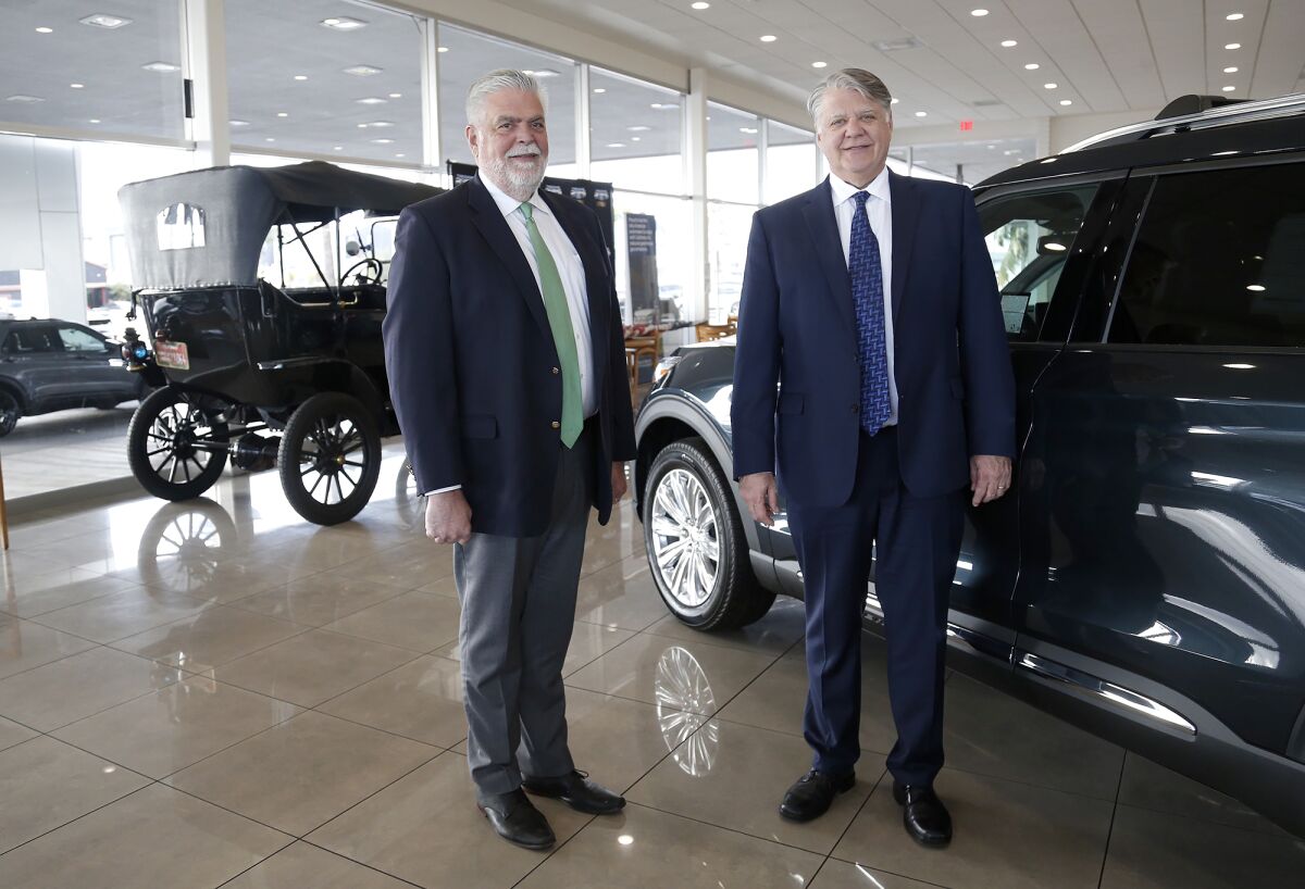 Jim and Dave Robins, from left, celebrated the 100th anniversary of the Theodore Robins Ford dealership in Costa Mesa.