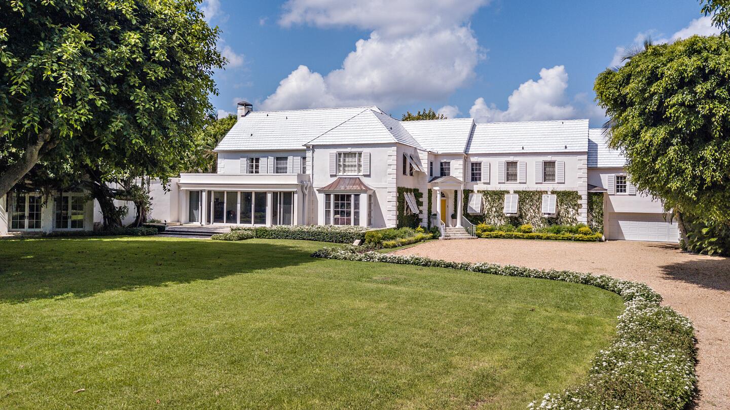 A large, two-story house with a big lawn.