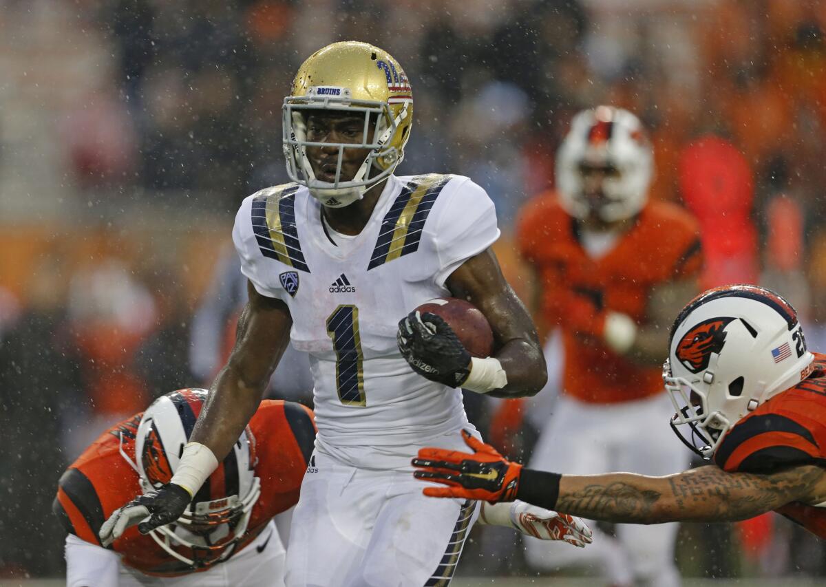 UCLA running back Soso Jamabo splits a pair of Oregon State defenders on his way to a 30-yard touchdown run during the third quarter of a game on Nov. 7.