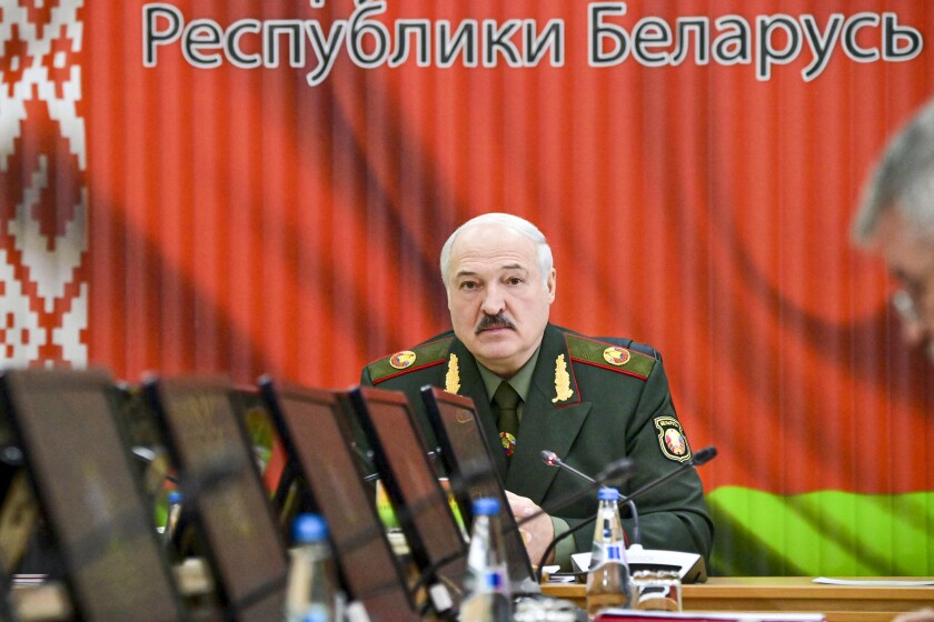 FILE - Belarusian President Alexander Lukashenko attends a meeting with top level military officials in Minsk, Belarus, on Nov. 22, 2021. A human rights group in Belarus says authorities have raided the homes of dozens of journalists and activists. The Viasna human rights center reported that independent journalists, human rights advocates and activists in at least nine large Belarusian cities had phones and computers seized during the searches and were interrogated. (Andrei Stasevich/BelTA Pool Photo via AP, File)