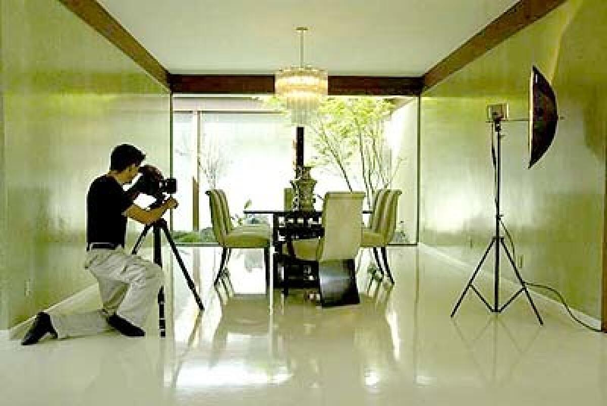 Art Gray sets up a professional photo shoot in Diane and David Gleans dining room.
