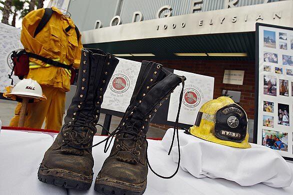 The boots of Los Angeles County Fire Department Capt. Tedmund "Ted" Hall are displayed with his other firefighting equipment before the start of a memorial at Dodger Stadium in Los Angeles Saturday. Hall and fellow firefighter Arnaldo "Arnie" Quinones died while helping to battle the recent Station fire in the mountains north of the city.