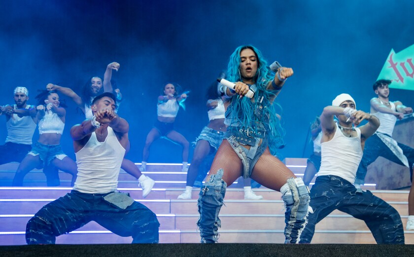 With her bright blue hair, Karol G performs with two dancers on Coachella's main stage. 