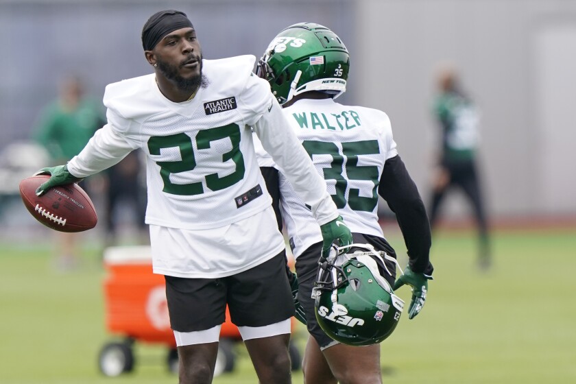 New York Jets running back Tevin Colman (23) tosses the football to an assistant after participating in running drills during an NFL football practice, Wednesday, June 2, 2021, in Florham Park, N.J. (AP Photo/Kathy Willens)